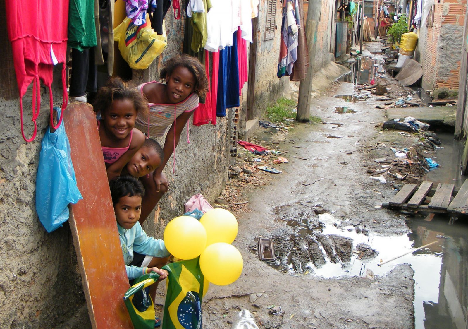 Indiferentes à falta de saneamento e de lugares para brincar, crianças da Favela do Mandela comemoram a Copa do Mundo